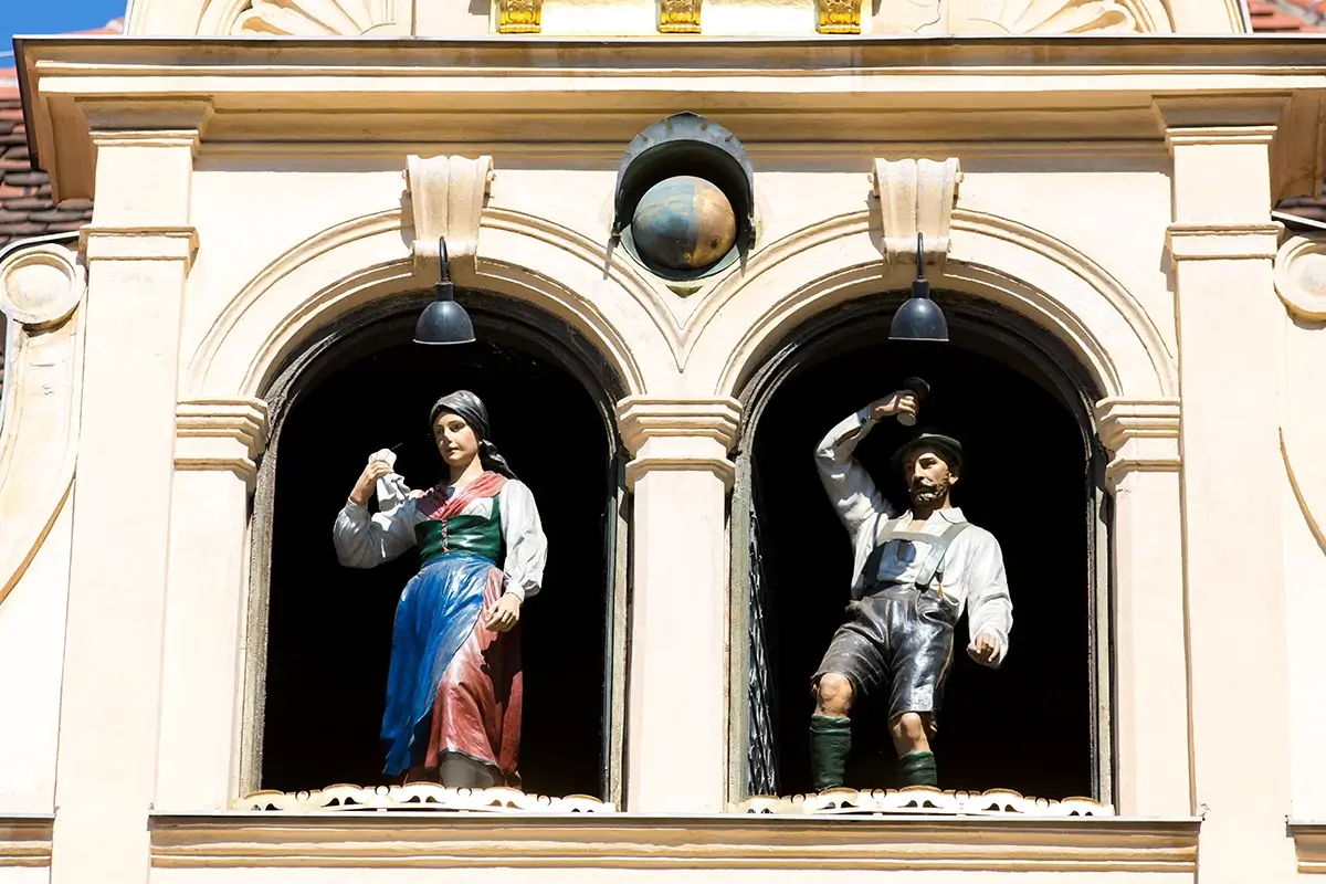 Traditional wooden dancers of the Graz Glockenspiel appearing above the clock, highlighting things to do in Graz.