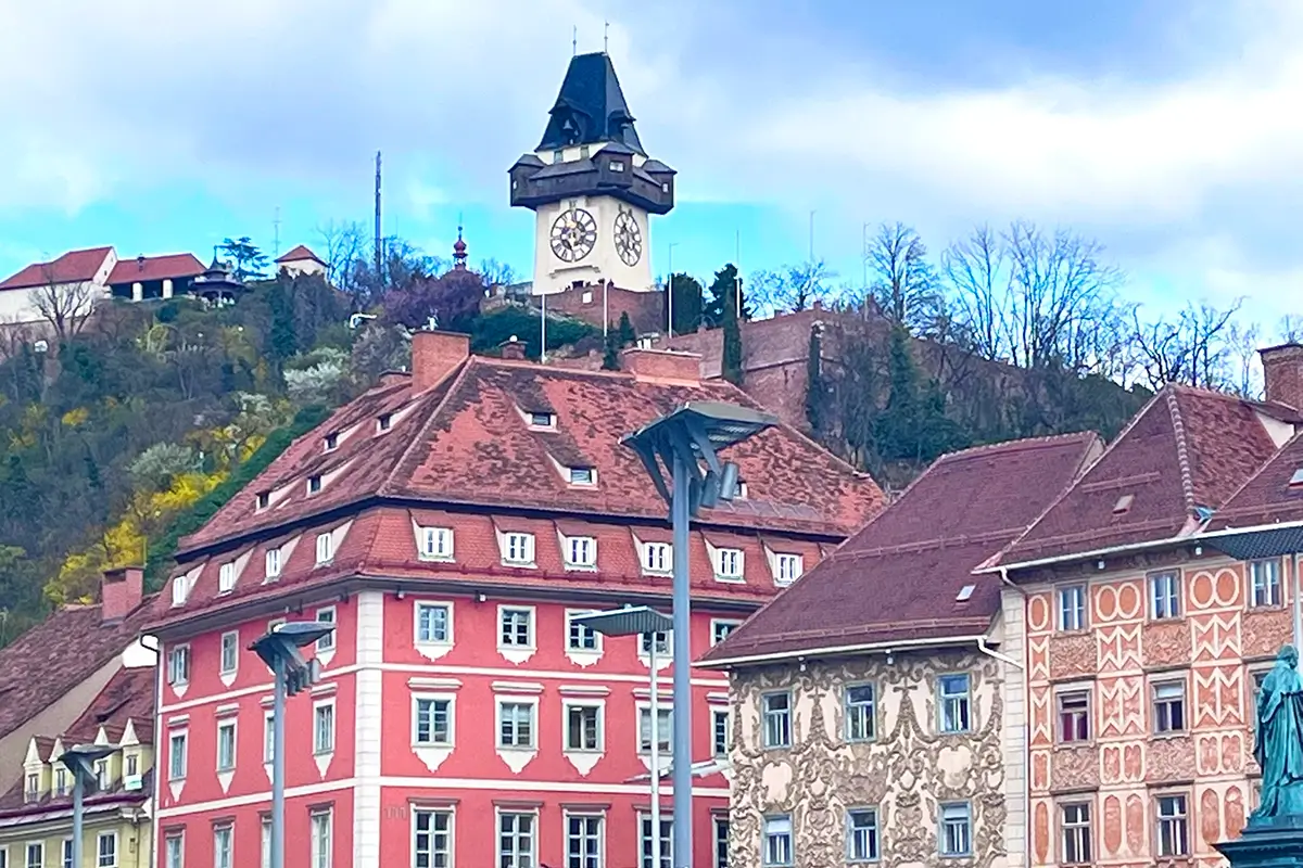 View of Graz Hauptplatz with the Uhrturm, colorful historic buildings, and ornate facades, highlighting things to do in Graz.