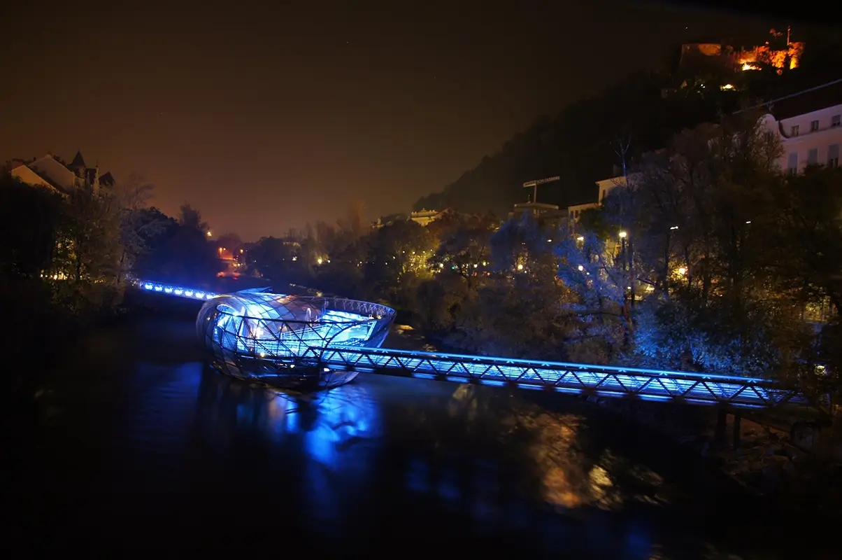 Murinsel illuminated in blue at night on the Mur River in Graz, highlighting things to do in Graz