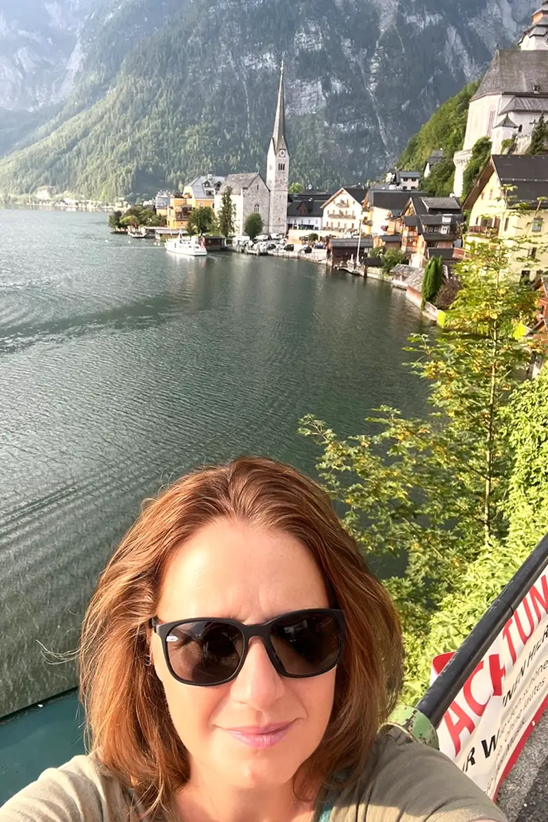 Tammy the founder of Austria Wanderlust and Wanderlustria at the famous photo spot showing Hallstatt village and Hallstättersee
