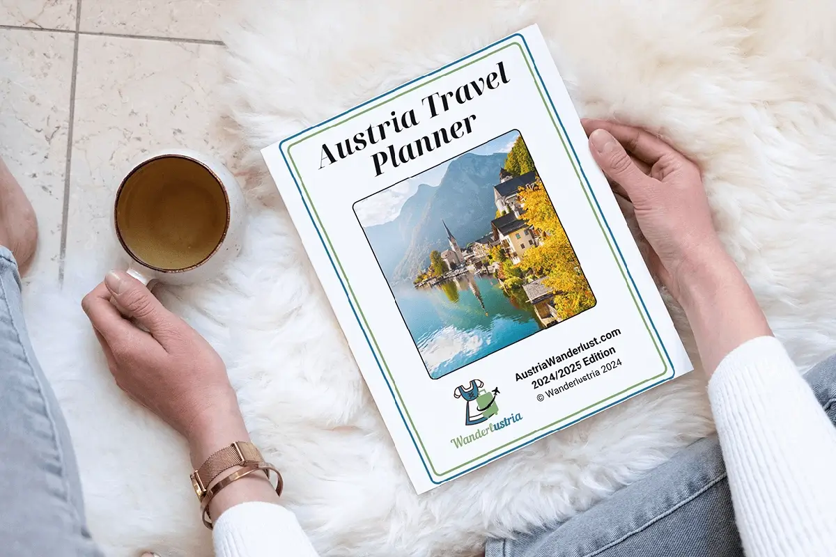 Woman sittting with a Coffee and reading the Austria Travel Planner Document