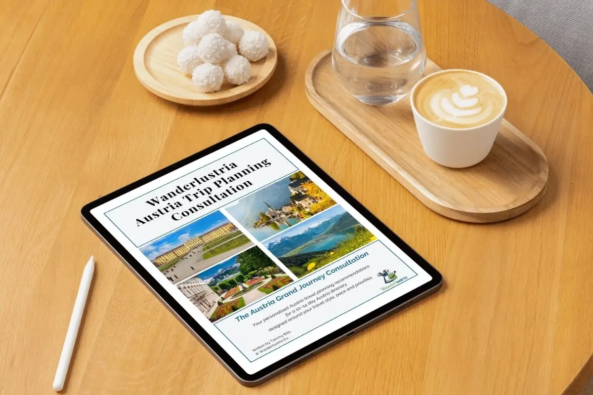 Austria Travel Plan Consultation on a iPad on a wooden table next to a coffee and snack